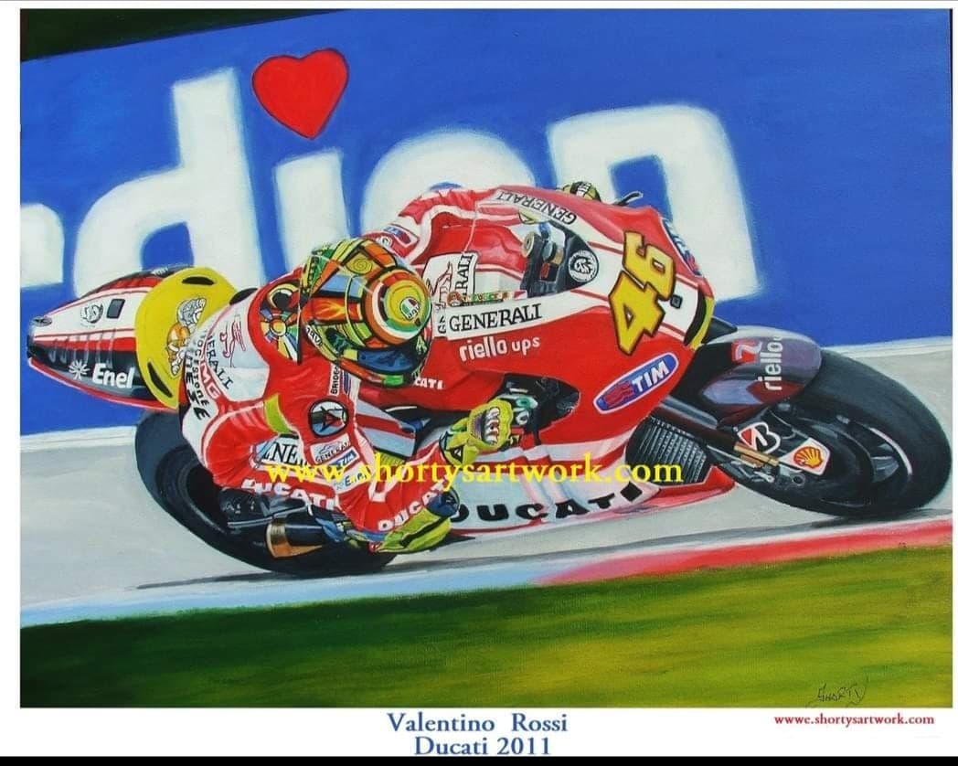 Valentino Rossi at full lean on the number 46 Ducati MotoGP machine